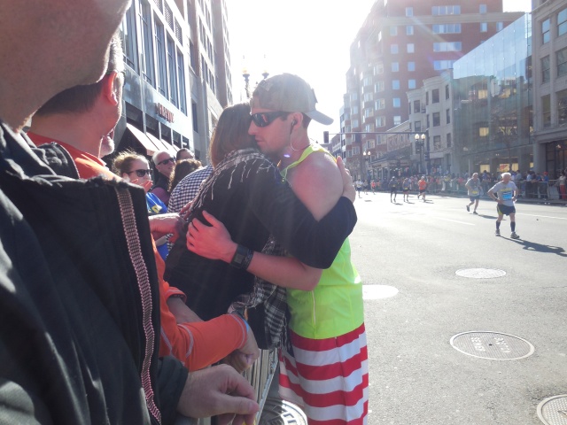 A mom hugging her son as he is about to cross the finish line.  He was running for Team Spalding Rehab